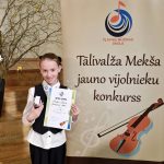 Rēzija Rīna pie Pļaviņu Mūzikas skolas rīkotā konkursa stenda.