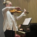 Viktorija Tjuha spēlē vijoli.