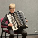 Gustavs Bergmanis spēlē akordeonu.